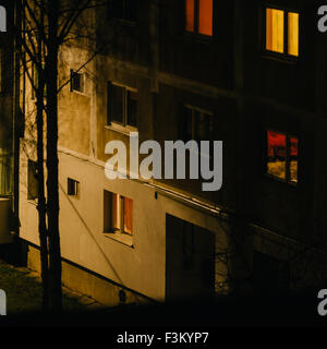 Apartments, windows, des lumières, des blocs de béton dans la nuit en Roumanie, maisons en panneaux construits dans le communisme. Scènes urbaines. Banque D'Images