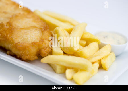 Sauce tartare, frites et poisson pané frit sur une plaque blanche sur un fond blanc. Banque D'Images