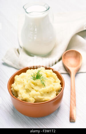 Purée de pommes de terre et pot de lait sur tableau blanc Banque D'Images