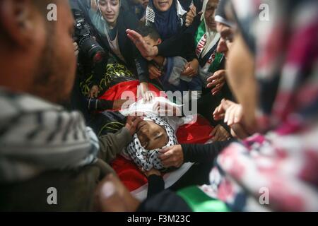 (151009) -- RAMALLAH, 9 octobre 2015 (Xinhua)-- parents de Mohannad palestinienne Halabi, 19 ans, de rassembler autour du corps lors de ses funérailles dans la ville de Ramallah, en Cisjordanie, le 9 octobre 2015. Halabi a été tué par la police israélienne après avoir poignardé un colon morts et blessant quatre autres dans la vieille ville de Jérusalem. (Xinhua/Fadi Arouri) (l'azp) Banque D'Images