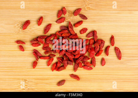 Pile de baies de goji sec sur une planche en bois Banque D'Images