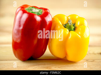 Dynamique, coloré en rouge et jaune sur le billot de bois capsicum Banque D'Images