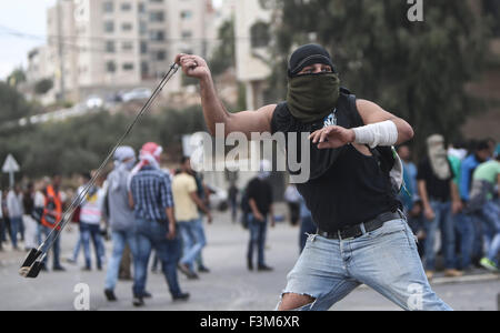 (151009) -- RAMALLAH, 9 octobre 2015 (Xinhua) -- un manifestant palestinien lance des pierres sur des soldats israéliens, au cours d'affrontements dans la région de Beit El à la périphérie de la ville de Ramallah, en Cisjordanie, le 9 octobre 2015. Les médecins ont signalé que 6 manifestants blessés par balles réelles, d'autres avec 20 balles en caoutchouc. (Xinhua/Fadi Arouri) (l'azp) Banque D'Images