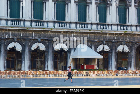 Femme en marche en face du Caffe Florian dans une zone vide de la Piazza San Marco Venise Vénétie Italie Europe Banque D'Images
