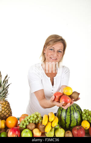 De nombreux fruits empilés et cute woman Banque D'Images