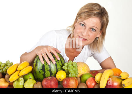 De nombreux fruits empilés et cute woman Banque D'Images