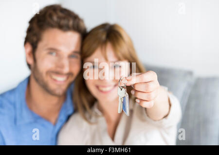 Cheerful couple vieille de trente ans montrant une clefs de leur nouvel appartement. Propriétaire de bonheur Banque D'Images