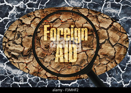 L'aide étrangère texte sous une loupe sur abstract background Banque D'Images