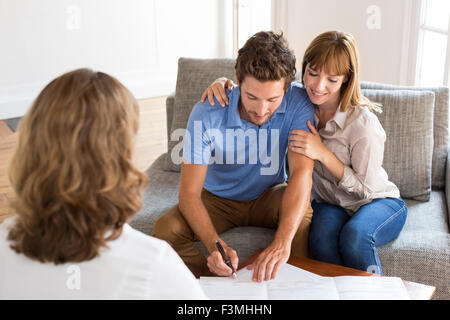 Deux jeunes propriétaires de bonheur pour l'agent immobilier réunion vacances l'investissement. La signature d'un contrat Banque D'Images