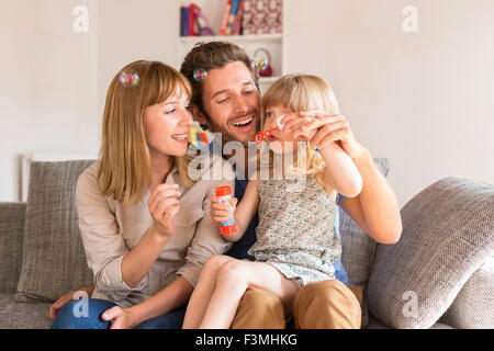 Les parents gais et sa fille faire des bulles en blanc maison moderne Banque D'Images