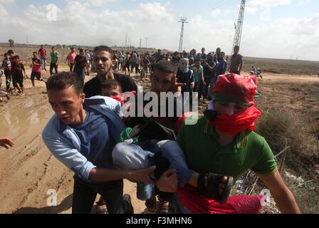La ville de Gaza, bande de Gaza, territoire palestinien. 9 octobre, 2015. Un manifestant palestinien est évacué par ses camarades après avoir été blessé lors d'affrontements avec les forces de sécurité israéliennes près de la frontière entre Israël et la bande de Gaza le 9 octobre 2015 à l'est de la ville de Gaza. Tension et de protestations ont augmenté après un israélien le 09 octobre poignardé quatre Palestiniens dans le sud d'Israël, dans ce qui est considéré comme une attaque de vengeance, ont dit. Le 08 octobre plusieurs incidents violents s'est produit, y compris à l'arme blanche qui a fait huit blessés israéliens, un Palestinien a été tué à Jérusalem Est et dans les six