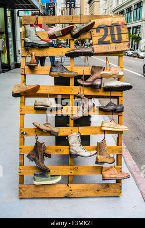 Chaussures en bois trottoir affichage de différents types de bottes sur la rue dans le centre-ville de San Francisco, Californie, USA avec un signe pour 20 Banque D'Images