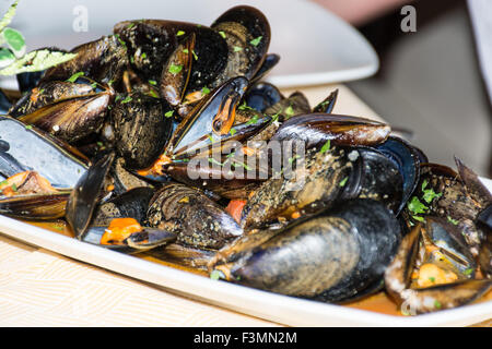 Un plat de moules des photos avec la sauce tomate, ouvert, prêt à manger, d'une table se propager. Banque D'Images