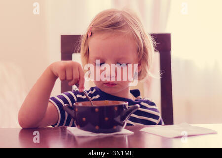 Petite fille mignonne mange de la soupe. Focus sélectif. Banque D'Images