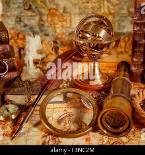 Vintage still life. Vintage loupe réside, montre de poche, livre ancien et astrolabe sur une ancienne carte du monde en 1565. Banque D'Images