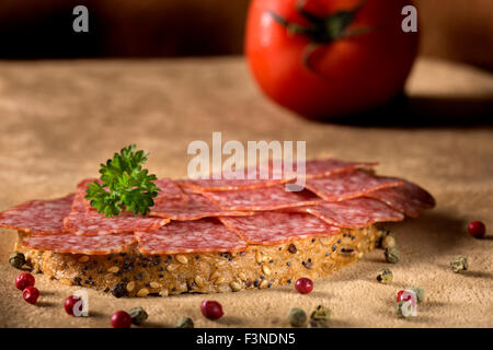 Photo de délicieux sandwich salami avec des grains de poivre et persil Banque D'Images