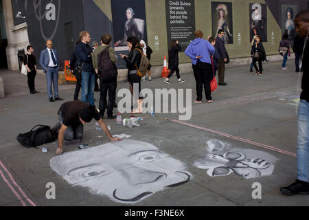 Un artiste de rue travaille sur son morceau de la chaussée en face de Goya portraits, sponsorisé par le Credit Suisse et annoncé sur un panneau publicitaire de la construction en dehors de la National Portrait Gallery. Banque D'Images