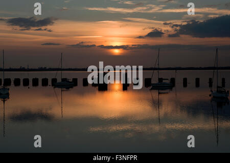 Coucher du soleil sur le pont Billy Hayling. Vue sur le port de Langstone vers le soleil couchant derrière Portsmouth le calme d'un soir. Banque D'Images