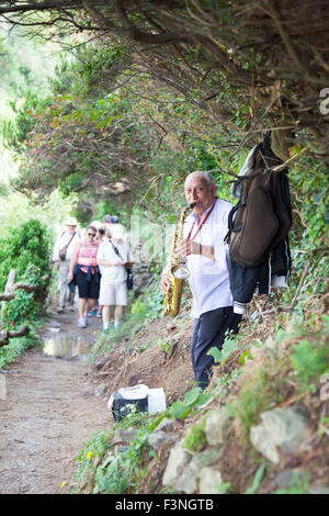 Musicien jouant du saxophone sur la randonnée à partir de Monterosso al Mare à Vernazza, Cinque Terre, Italie Banque D'Images