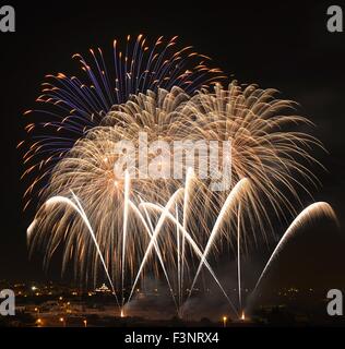 Arrière-plan coloré,Fireworks Fireworks Fireworks,explosion de ciel noir avec village silhoutte of mountain range at sunset dans Fireworks, Malte,Qrendi Banque D'Images