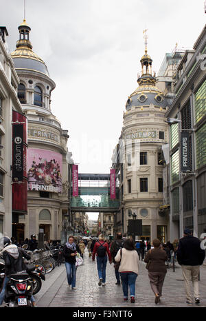 Corporation Shoppers flânant dans les quartier de l'Opéra avec le dôme au magasin Le Printemps dans l'arrière-plan. Paris, France. Banque D'Images
