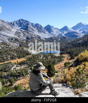 Randonneur au repos en admirant la vallée des lacs dans la région de Rock Creek Canyon dans l'Est de la Sierra en Californie du Nord Banque D'Images