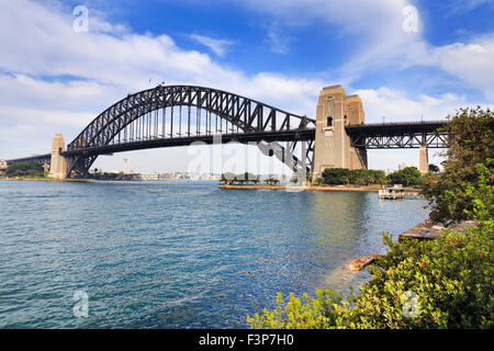 Vue latérale de Sydney Harbour Bridge de Milsons Point lumineux sur la journée ensoleillée d'été avec des arbres verts entourant port eau Banque D'Images