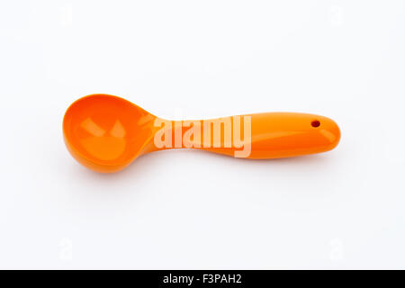Cuillère à crème glacée de couleur orange sur fond blanc Banque D'Images