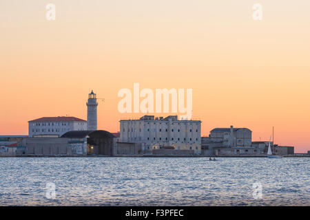 Le port de Trieste Harbour, au crépuscule d'une pratique de l'équipe d'aviron sur les eaux calmes de la mer Adriatique. Banque D'Images