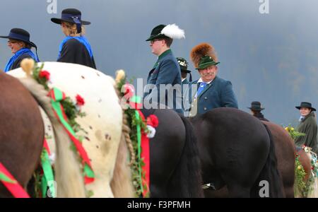 Füssen, Allemagne. Oct 11, 2015. Les femmes et les hommes en costume traditionnel s'asseoir sur les chevaux décorés de fête près de Füssen, Allemagne, 11 octobre 2015. Ils participent à la fête de saint Coloman, qui est célébrée à Schwangau chaque année. Les coureurs prennent part à une procession et messe, au cours de laquelle les chevaux sont bénis. Selon la légende, l'Irlandais Coloman reposé, prêché et vécu en troupeaux bovins dans Schwangau pendant son pèlerinage de l'Irlande à Jérusalem. PHOTO : Karl Josef OPIM/DPA/Alamy Live News Banque D'Images