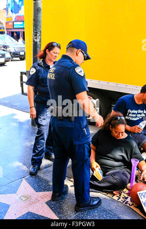 Hollywood boulevard les agents de sécurité privé patrouille parler à un couple de mendiants sur le Walk of Fame à Los Angeles CA Banque D'Images