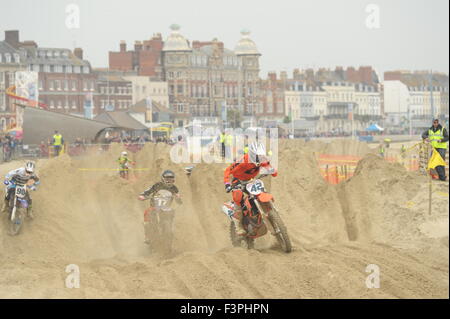 Weymouth, Dorset, UK - 11 octobre 2015. Lion's Beach annuel week-end de motocross sur plage de Weymouth. Weymouth et Portland Lion's organisent conjointement l'événement populaire avec club de motocross de Purbeck qui attire des centaines de coureurs, dont le test eux-mêmes sur la plage difficile course - Riders en compétition sur le parcours avec l'arrière-plan spectaculaire front de mer de Weymouth - Photo : Graham Hunt/Alamy Live News Banque D'Images