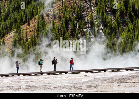 Les visiteurs du parc à pied sur la promenade le long de Grand Prismatic Spring, Midway Geyser Basin, Parc National de Yellowstone, Wyoming, USA Banque D'Images