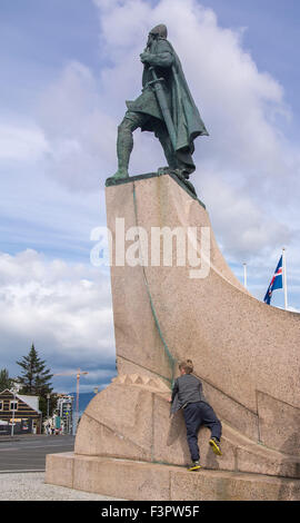 Reykjavik, Islande. 29 juillet, 2015. Un jeune garçon monte sur le piédestal d'une statue de l'explorateur Leif Eriksson par le célèbre sculpteur Alexander Calder est dans un centre commercial en face de l'église historique HallgrÃ-mskirkja à Reykjavik, capitale de l'Islande. C'était un cadeau aux États-unis commémorant le 1000e anniversaire de le parlement islandais à Pingvellir en 930 AD et est le site touristique s'arrêter. © Arnold Drapkin/ZUMA/Alamy Fil Live News Banque D'Images