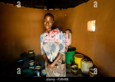 Femme avec bébé en logement traditionnel, Zambie, Afrique Banque D'Images