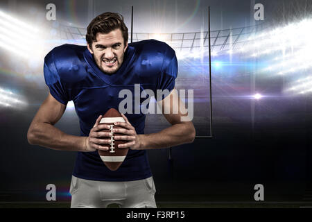 Image composite de l'agressivité american football player holding ball Banque D'Images