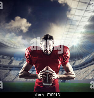 Image composite de joueur de football américain agressif en maillot rouge holding ball Banque D'Images