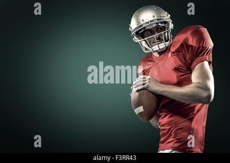 Image composite de joueur de football américain maillot rouge en lançant la balle Banque D'Images