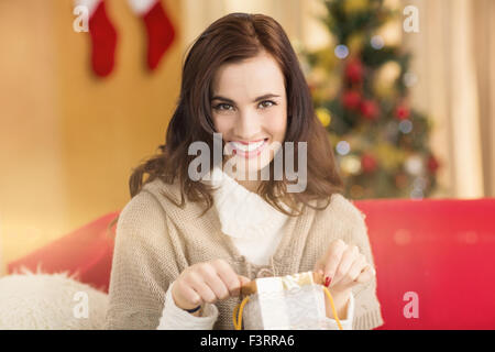 Brunette l'ouverture d'un cadeau sur la table à Noël Banque D'Images