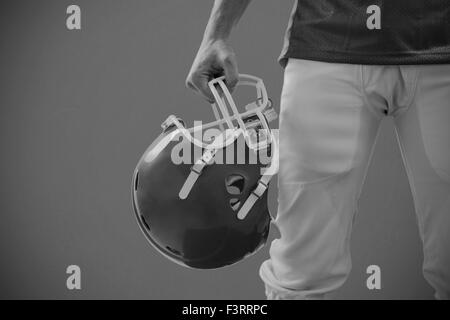 Image composite d'un joueur de football américain de prendre en main son casque Banque D'Images