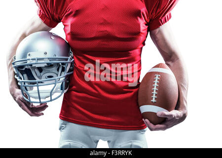 Portrait American football player holding helmet et ball Banque D'Images