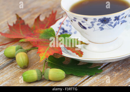 Les feuilles d'automne, les glands et tasse de thé noir Banque D'Images