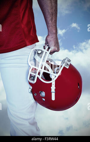 Image composite du milieu du rugby player holding helmet Banque D'Images