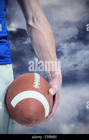 Image composite du milieu des sports player holding ball Banque D'Images