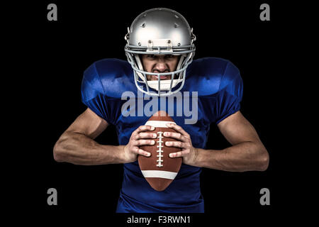 Image composite de portrait de joueur de football américain agressif holding ball Banque D'Images