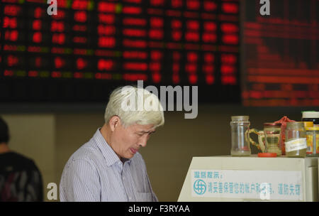 Hangzhou, Chine. 12 octobre, 2015. Un citoyen est perçu à un marché de stocks à Hangzhou, Zhejiang Province de Chine orientale, le 12 octobre 2015. L'indice Shanghai Composite Index a augmenté de 3,28  % pour terminer à 3 287,66 points, lundi. La composante de Shenzhen a progressé de 4 pour cent pour clôturer à 10 961,36 points. Source : Xinhua/Alamy Live News Banque D'Images