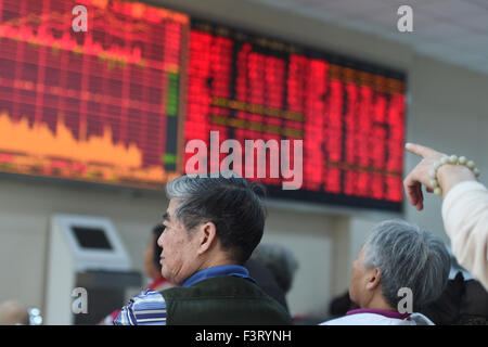 Hangzhou, Chine. 12 octobre, 2015. Un citoyen est perçu à un marché de stocks à Hangzhou, Zhejiang Province de Chine orientale, le 12 octobre 2015. L'indice Shanghai Composite Index a augmenté de 3,28  % pour terminer à 3 287,66 points, lundi. La composante de Shenzhen a progressé de 4 pour cent pour clôturer à 10 961,36 points. Source : Xinhua/Alamy Live News Banque D'Images