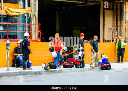 Les travailleurs de la construction d'attendre au bord du trottoir pour la balade hors de Los Angeles Californie Banque D'Images