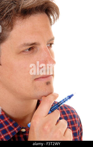 Gros plan d'une photo d'un jeune homme, tenant un stylo bleu, en pensées profondes, isolées pour fond blanc. Banque D'Images