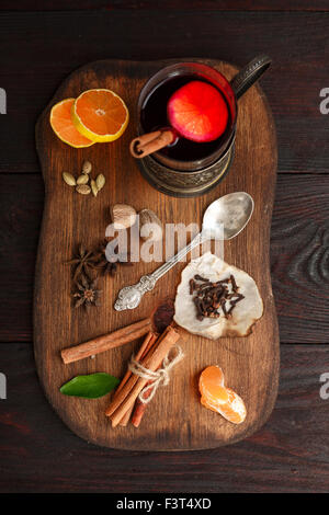 Verre de vin chaud (poinçon) Porte-verre en servi sur plaque en bois avec des épices sur la table en bois sombre. Vue d'en haut Banque D'Images